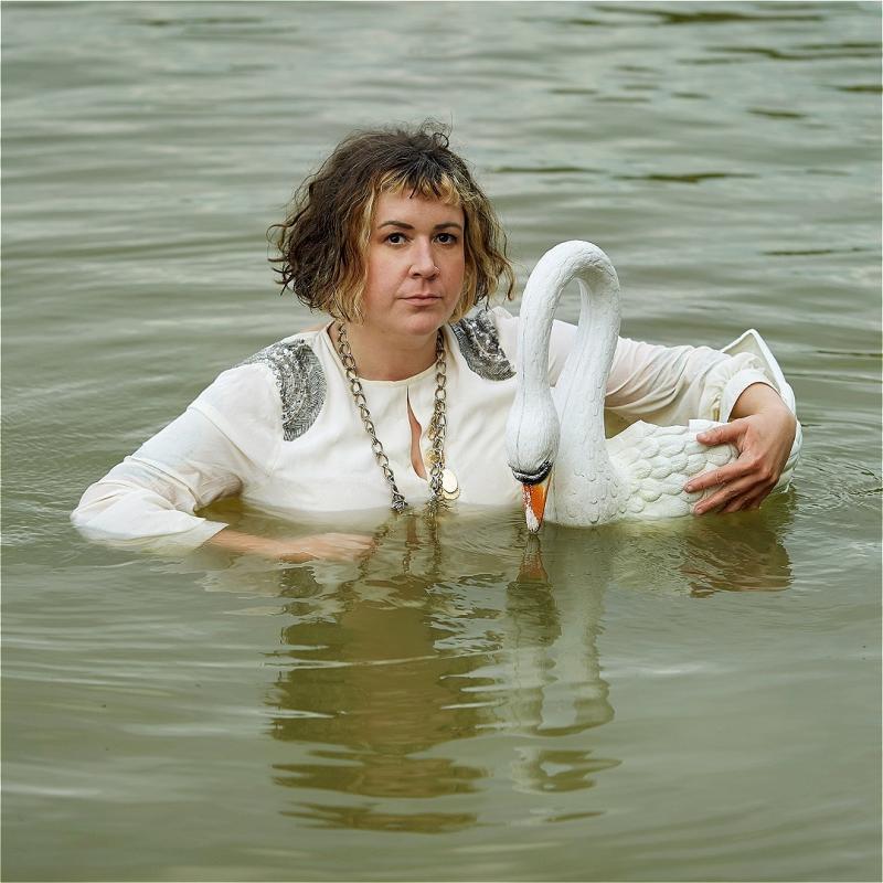 Amy submerged in the middle of a lake holding a plastic swan.