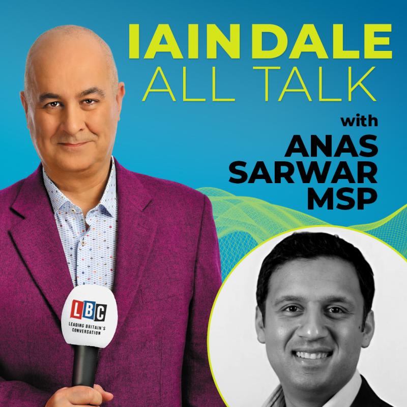 In front of a blue background, Iain Dale wears a purple suit and looks into the camera, holding a mic. Black and white headshot of Anas Sarwar MSP in bottom right.